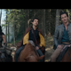 Fantasy heroes crack jokes while seated on horseback.